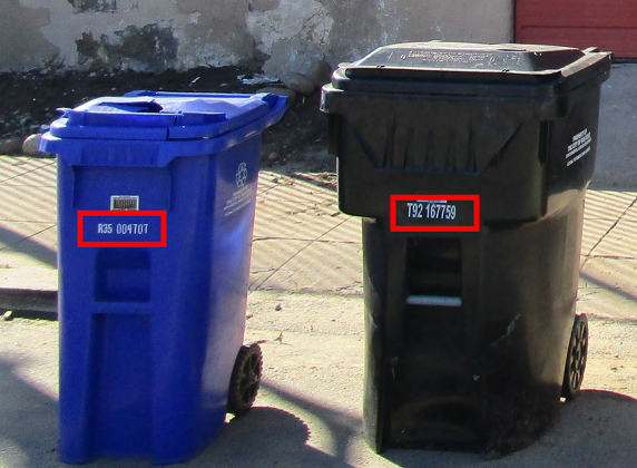 Two waste containers showing where to find the serial number: each cart has a barcode label with its serial number located on the front side, just below the lid.